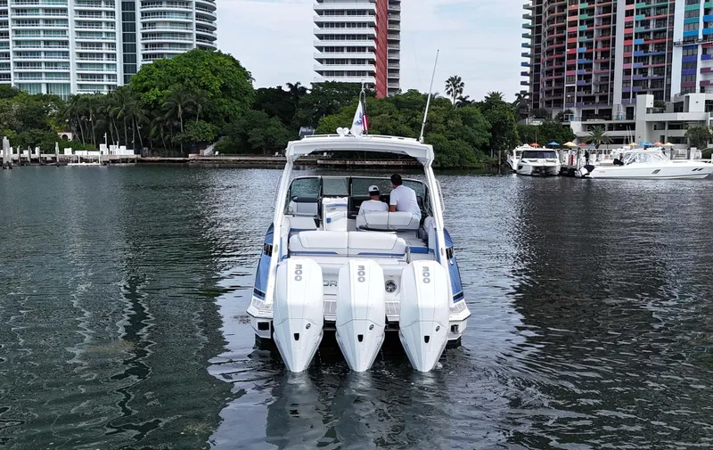 Slide: The Image of 2023 Formula 330 Crossover Bowrider OB cruising in urban waterfront setting. - 47