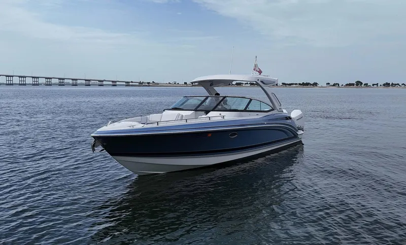Slide: The Image of 2023 Formula 330 Crossover Bowrider OB on calm water, bridge in background. - 48