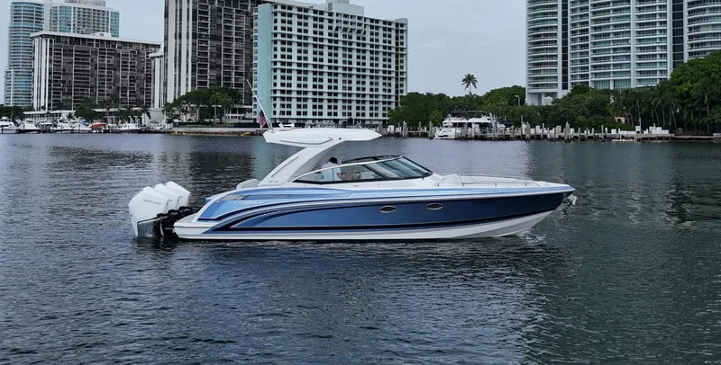 Slide: The Image of 2023 Formula 330 Crossover Bowrider OB on water, city skyline in background. - 49