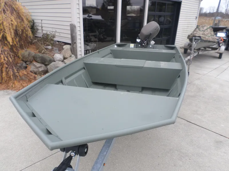 Slide: The Image of 2024 Polar Kraft DKMV 1648 boat on trailer, parked outside a building. - 2