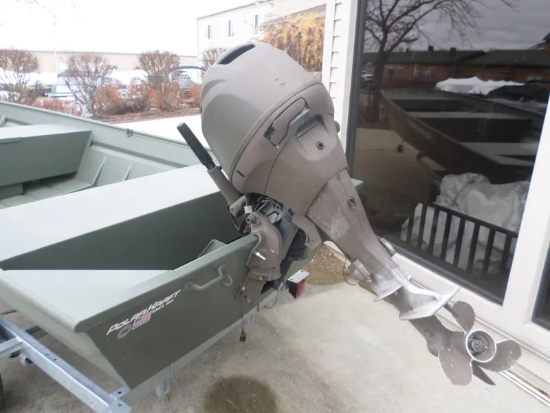 Slide: The Image of 2024 Polar Kraft DKMV 1648 boat with outboard motor, parked on a trailer. - 3