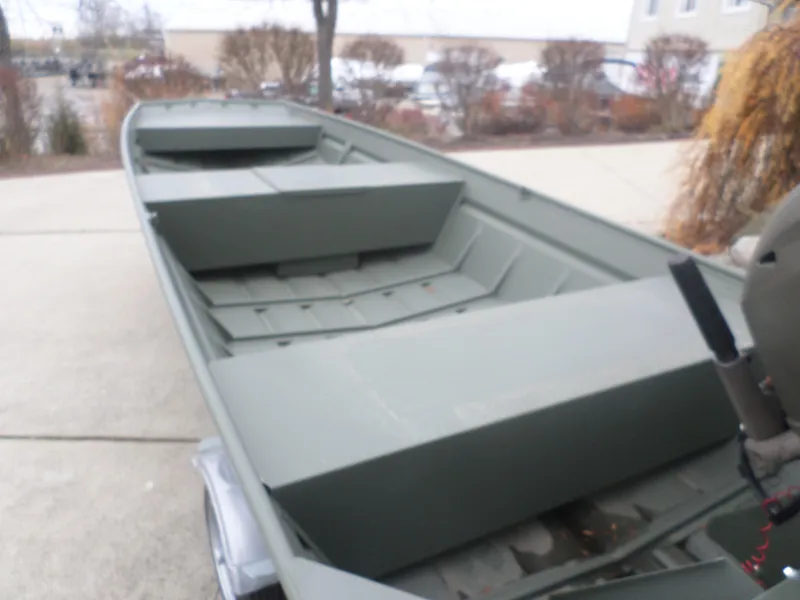 Slide: The Image of 2024 Polar Kraft DKMV 1648 boat, green interior, parked on concrete driveway. - 4