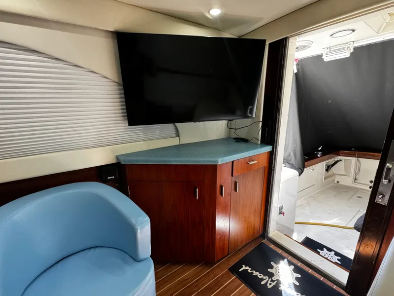 Slide: The Image of Interior of 1992 Ocean Yachts 48 Convertible with TV, blue chair, and wooden cabinetry. - 16
