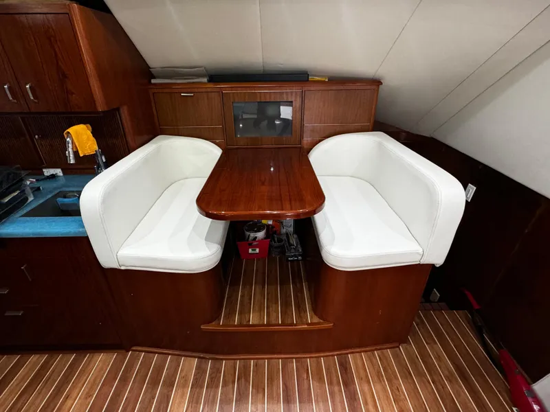Slide: The Image of Interior of 1992 Ocean Yachts 48 Convertible with wooden dining area and white seating. - 18