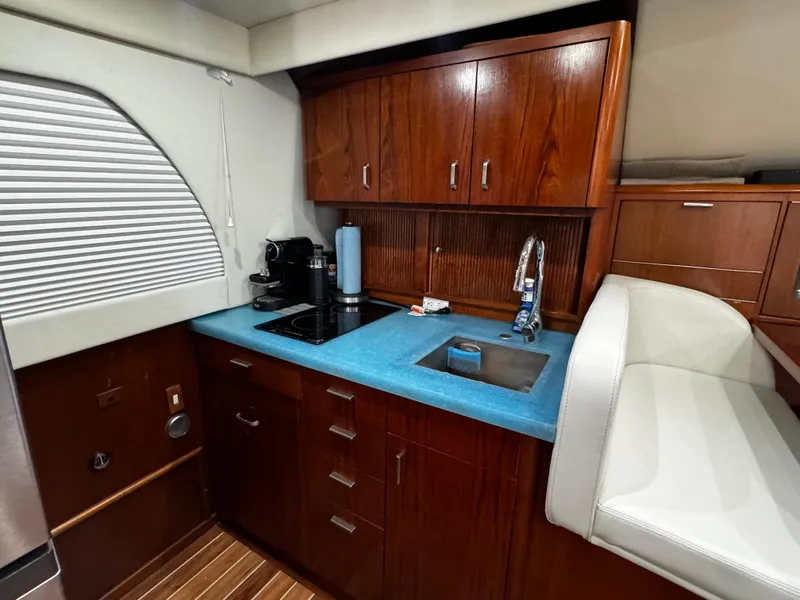 Slide: The Image of Luxurious kitchen interior of 1992 Ocean Yachts 48 Convertible with wooden cabinets and blue countertop. - 20