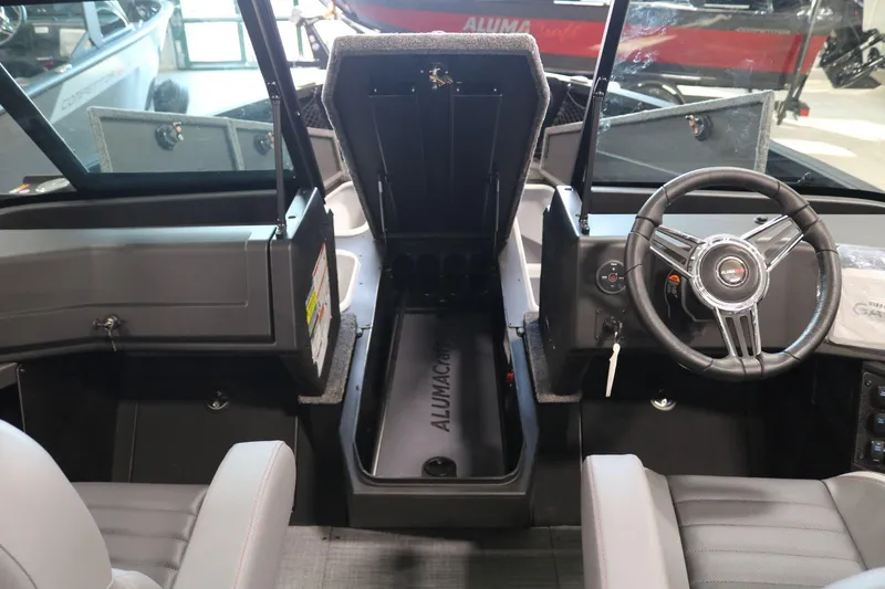 Slide: The Image of 2025 Alumacraft Competitor 175X Sport boat interior with steering wheel and storage compartment. - 10