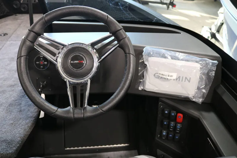 Slide: The Image of 2025 Alumacraft Competitor 175X Sport dashboard with steering wheel and Garmin device. - 15