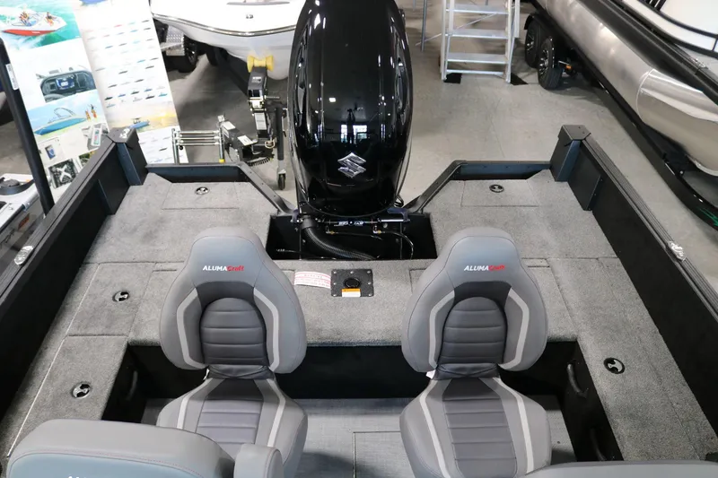 Slide: The Image of 2025 Alumacraft Competitor 175X Sport interior with dual seats and outboard motor. - 17