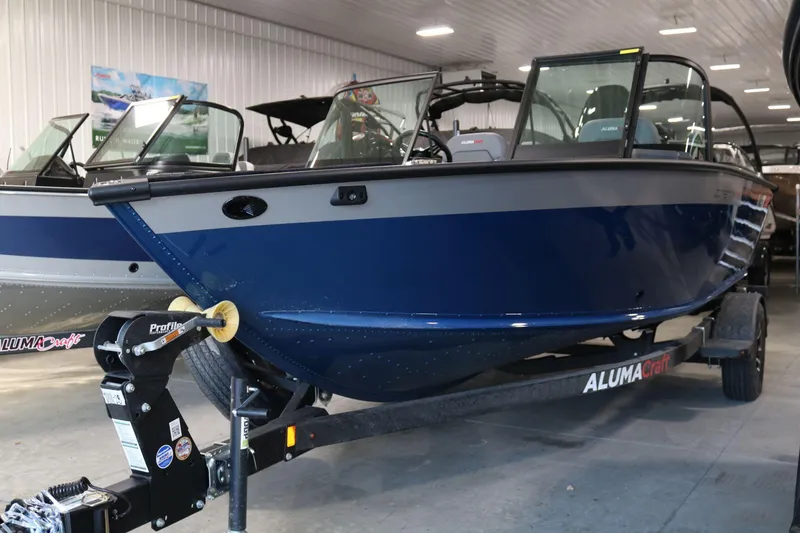 Slide: The Image of 2025 Alumacraft Competitor 175X Sport boat in showroom, blue exterior, on trailer. - 3