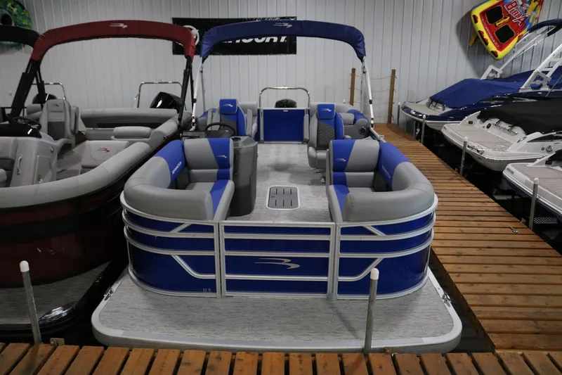 Slide: The Image of 2025 Bennington 22 S STERN RADIUS pontoon boat in showroom, blue and gray seating. - 2