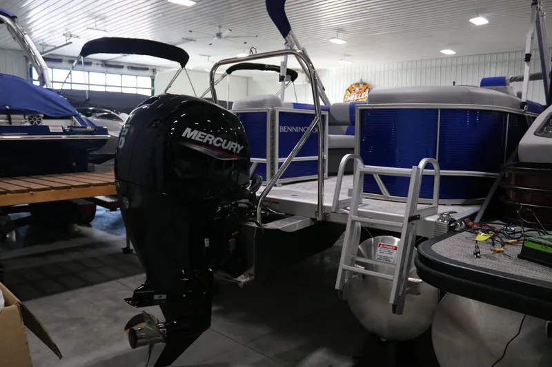 Slide: The Image of 2025 Bennington 22 S STERN RADIUS pontoon boat with Mercury outboard motor in showroom. - 21