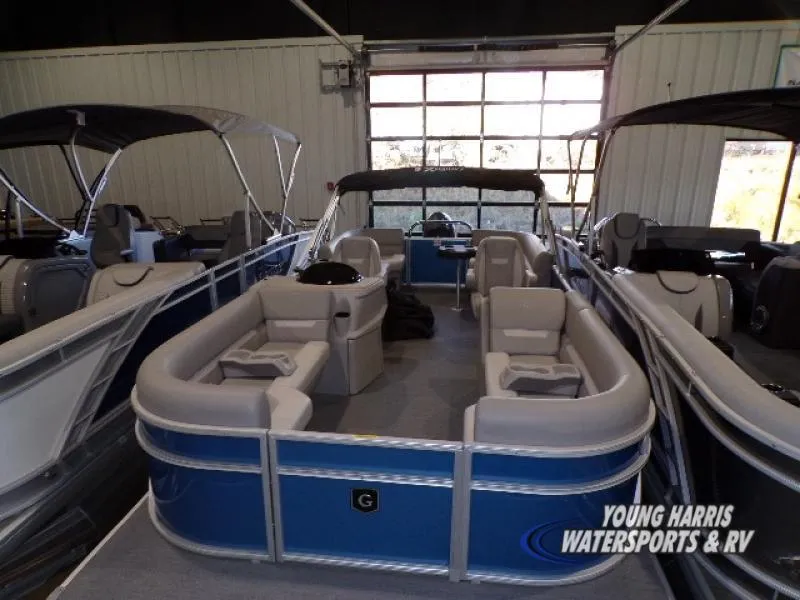Slide: The Image of 2025 Godfrey EX2286SB pontoon boat in showroom, featuring spacious seating and modern design. - 1
