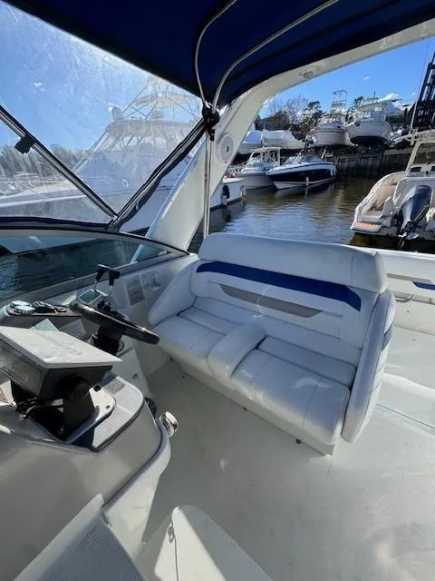 Slide: The Image of 2003 Formula 27 PC boat interior with white seating and marina view. - 24