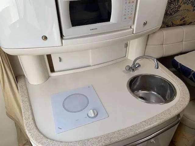 Slide: The Image of Compact kitchenette in 2003 Formula 27 PC boat with sink, stove, and microwave. - 8