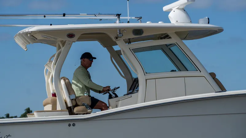 Slide: The Image of Man piloting 2012 Scout 345 XSF boat on a sunny day. - 10