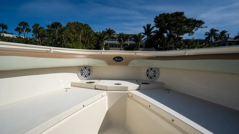 Slide: The Image of 2012 Scout 345 XSF boat interior with seating and speakers, surrounded by lush greenery. - 16