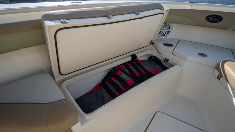 Slide: The Image of Open storage compartment on 2012 Scout 345 XSF boat with life jacket inside. - 18