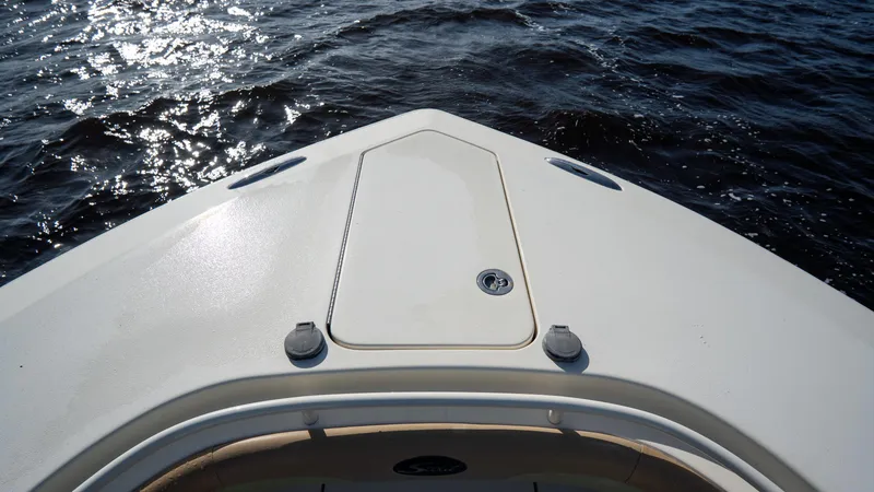 Slide: The Image of Bow of 2012 Scout 345 XSF boat on water, sun reflecting on surface. - 22