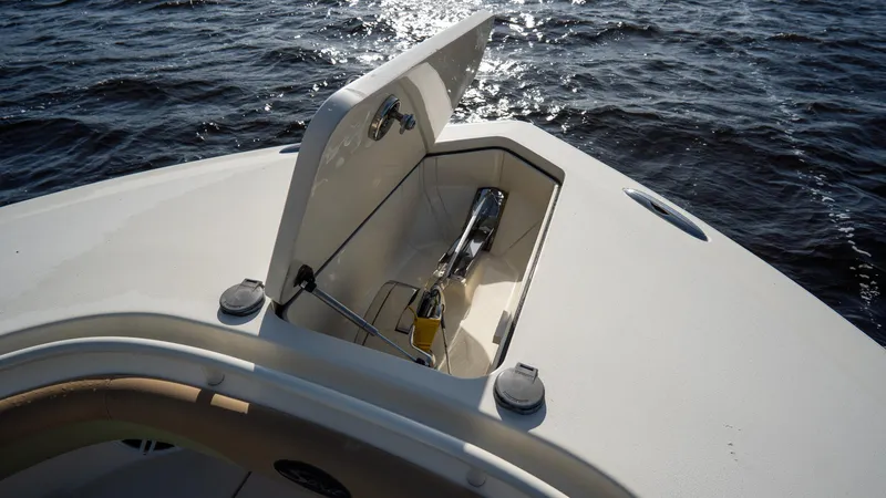 Slide: The Image of 2012 Scout 345 XSF boat anchor compartment open on calm water. - 23