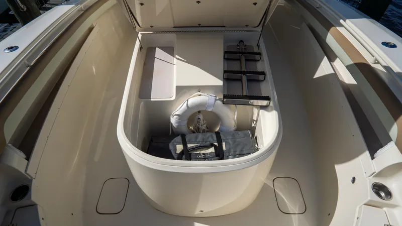 Slide: The Image of 2012 Scout 345 XSF boat storage compartment with life preserver and equipment. - 26
