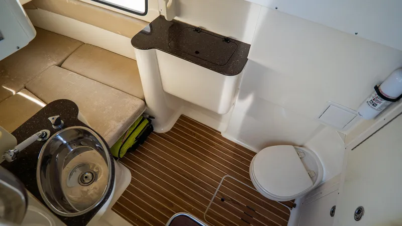 Slide: The Image of 2012 Scout 345 XSF boat interior with sink, toilet, and wooden flooring. - 37