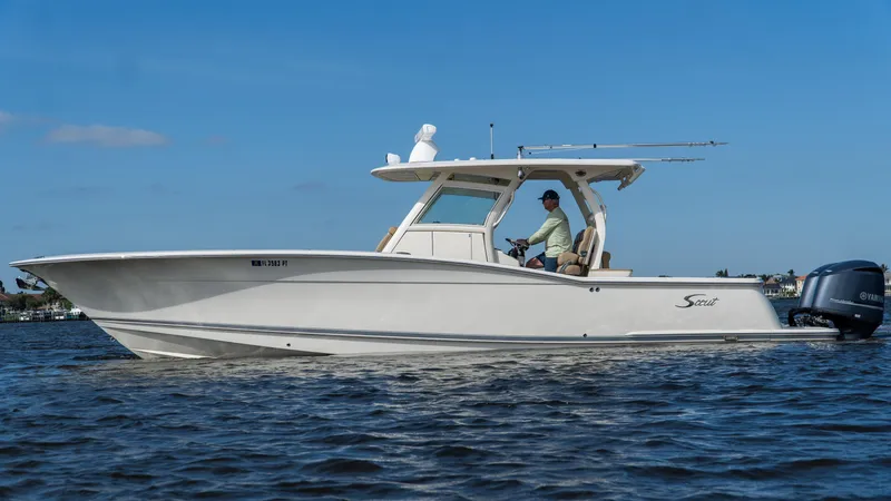 Slide: The Image of 2012 Scout 345 XSF boat cruising on open water under clear blue sky. - 4