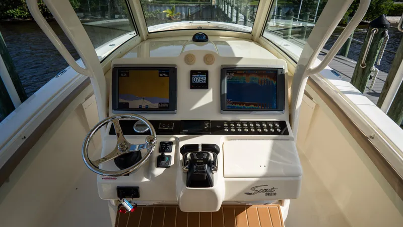 Slide: The Image of 2012 Scout 345 XSF boat dashboard with navigation screens and steering wheel. - 50