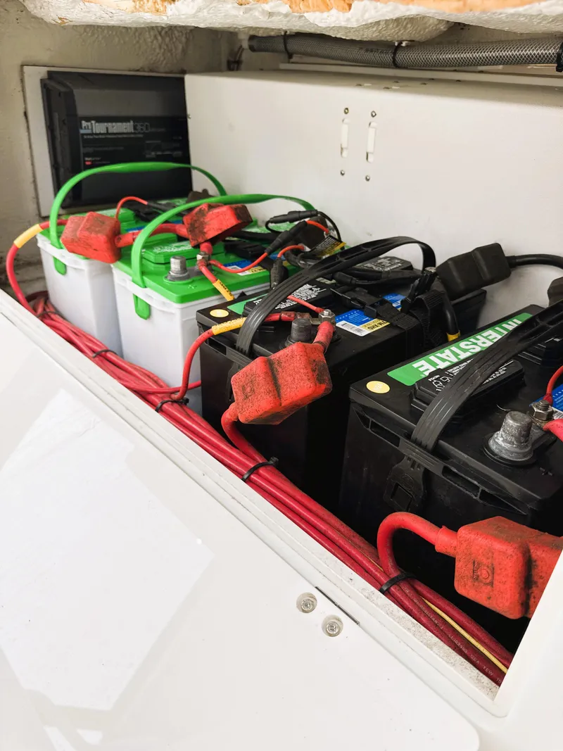 Slide: The Image of Batteries in a 2016 Cobia 296 Center Console boat, neatly arranged with red and green cables. - 23
