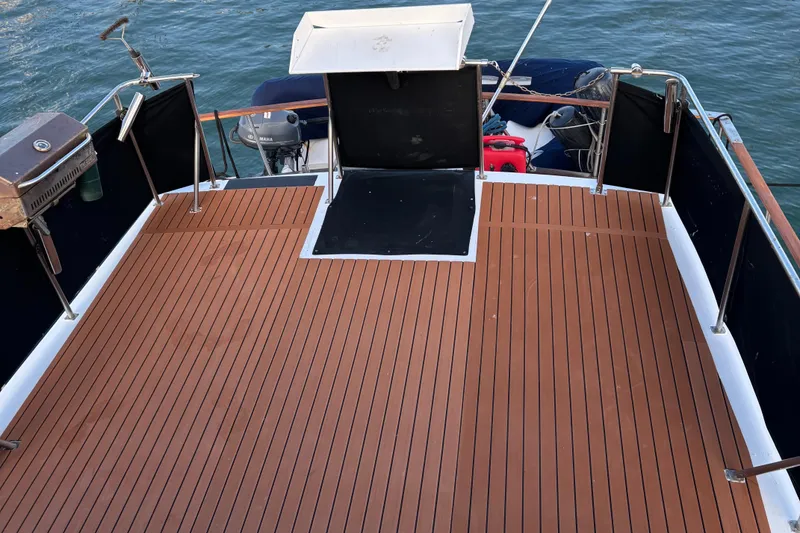 Slide: The Image of 1979 Ocean Yachts Trawler with spacious wooden deck and ocean backdrop. - 15