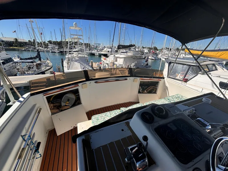 Slide: The Image of 1979 Ocean Yachts Trawler cockpit view in marina, showcasing helm and seating area. - 18