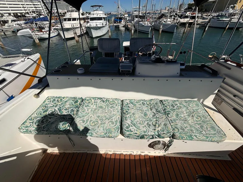Slide: The Image of 1979 Ocean Yachts Trawler with cushioned seating, docked in a marina. - 20