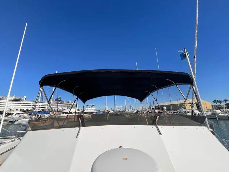 Slide: The Image of 1979 Ocean Yachts Trawler with canopy, docked in a marina under clear blue skies. - 21