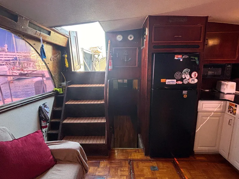 Slide: The Image of Interior of a 1979 Ocean Yachts Trawler with stairs, kitchen, and cozy seating area. - 26
