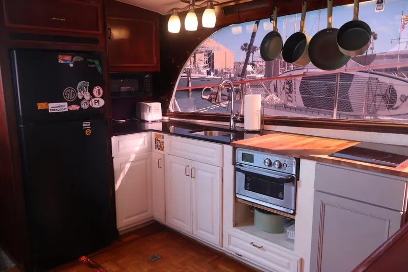 Slide: The Image of 1979 Ocean Yachts Trawler kitchen with modern appliances and marina view. - 27