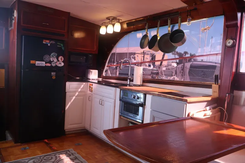 Slide: The Image of Interior of 1979 Ocean Yachts Trawler kitchen with modern appliances and hanging pots. - 30