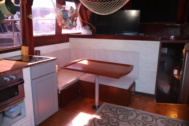 Slide: The Image of 1979 Ocean Yachts Trawler interior with dining area, kitchen, and TV. Cozy and functional design. - 31