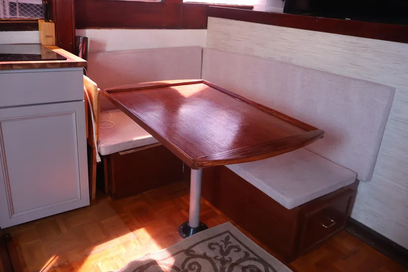 Slide: The Image of 1979 Ocean Yachts Trawler interior with wooden table and cushioned seating. - 32