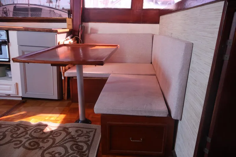 Slide: The Image of 1979 Ocean Yachts Trawler interior with cozy dining nook and wooden table. - 33