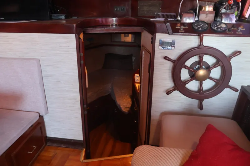 Slide: The Image of 1979 Ocean Yachts Trawler interior with wooden helm, cozy seating, and cabin entrance. - 37