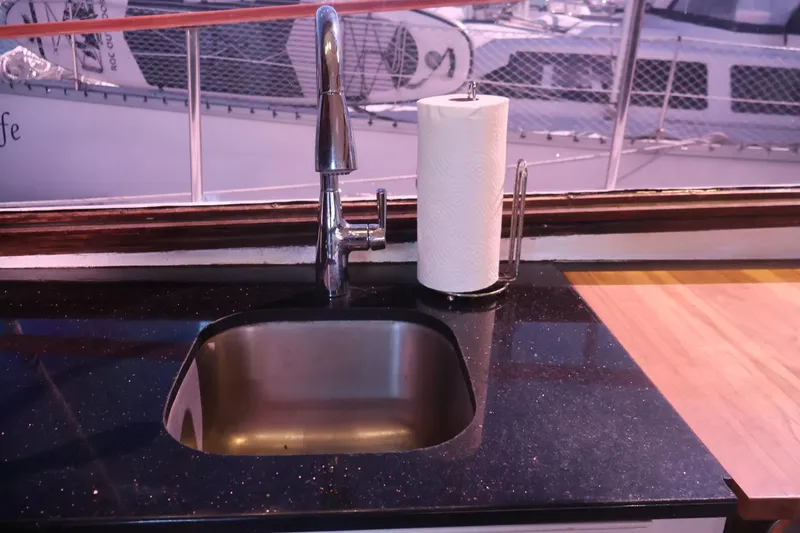 Slide: The Image of 1979 Ocean Yachts Trawler kitchen sink with paper towel holder, docked in marina. - 38