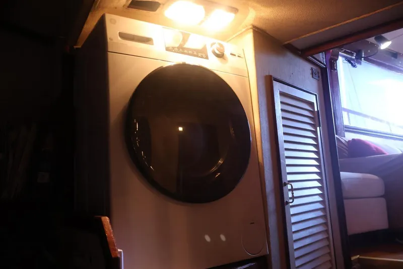 Slide: The Image of Laundry area inside 1979 Ocean Yachts Trawler with washer and cozy interior lighting. - 49