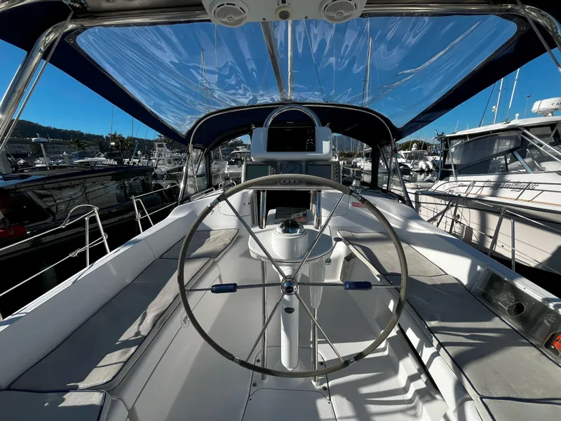 Slide: The Image of 2005 Hunter 41 sailboat cockpit with steering wheel, docked in marina. - 13