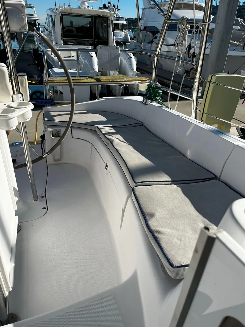 Slide: The Image of 2005 Hunter 41 sailboat cockpit with cushioned seating at marina. - 18