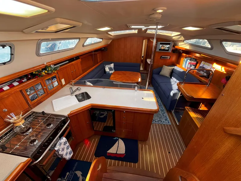 Slide: The Image of Interior of 2005 Hunter 41 sailboat with kitchen, seating, and wooden finishes. - 28