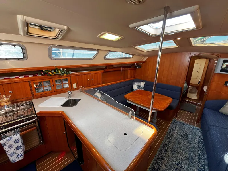 Slide: The Image of Interior of 2005 Hunter 41 sailboat with kitchen and seating area. - 32