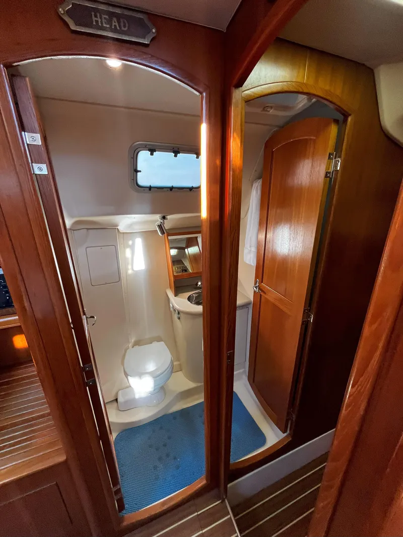 Slide: The Image of 2005 Hunter 41 yacht bathroom with wooden doors and compact toilet. - 33