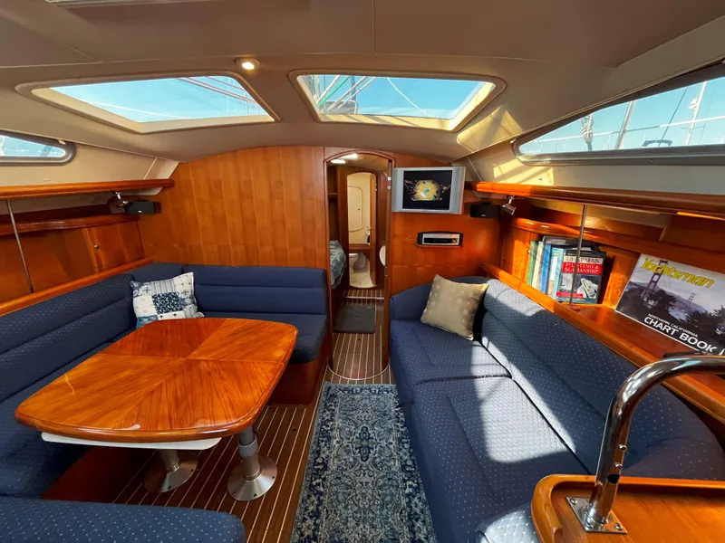 Slide: The Image of Luxurious 2005 Hunter 41 yacht interior with wood finish, skylights, and blue seating. - 36