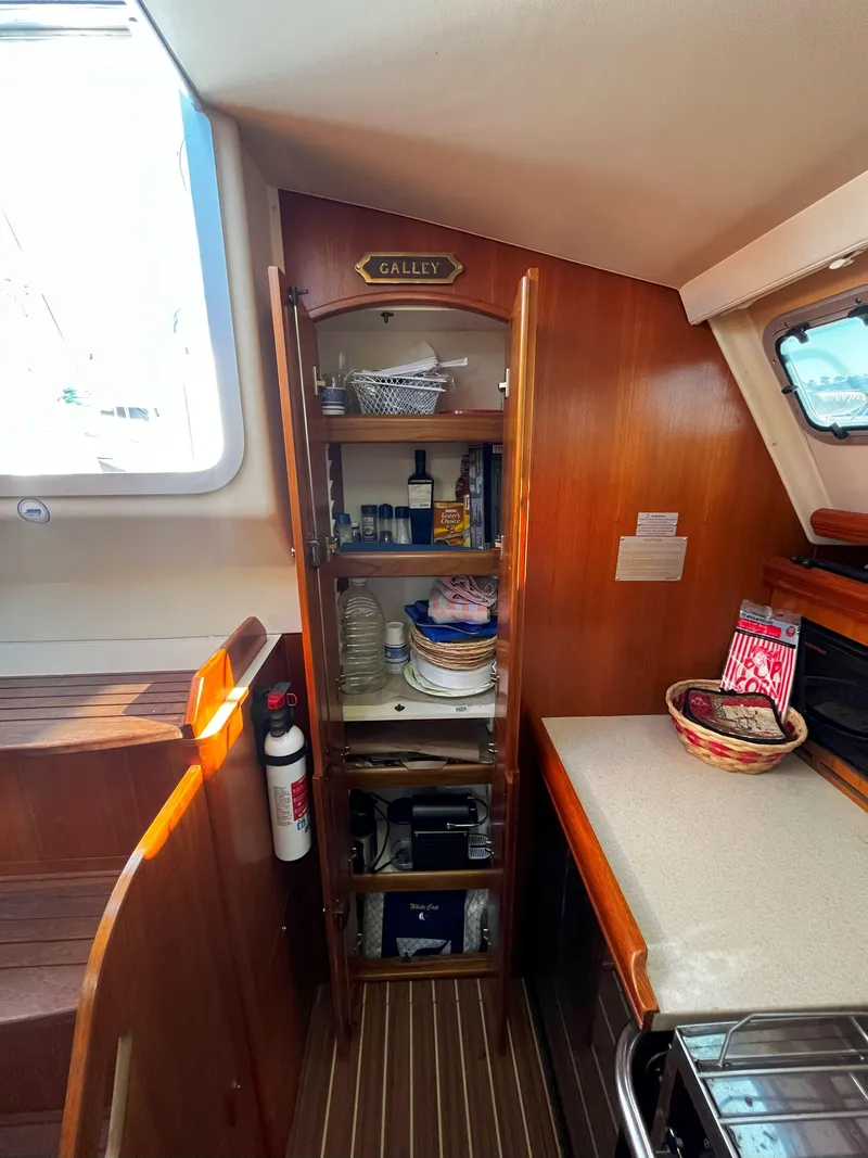 Slide: The Image of 2005 Hunter 41 sailboat galley with wooden cabinets and countertop. - 38
