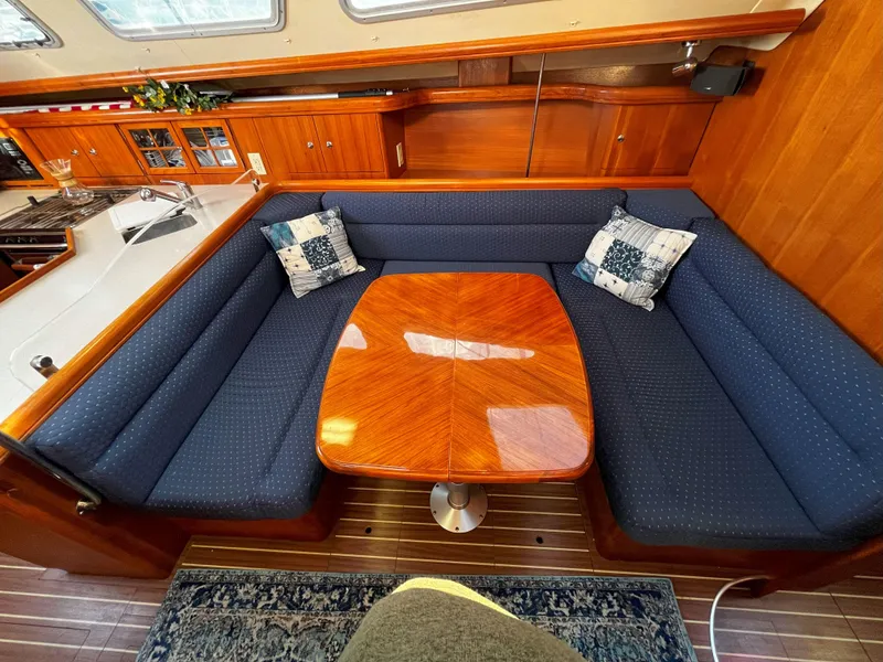 Slide: The Image of Luxurious 2005 Hunter 41 yacht interior with elegant wood table and blue cushioned seating. - 39