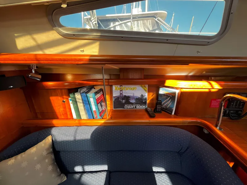 Slide: The Image of Cozy interior of 2005 Hunter 41 sailboat with books and chart book on shelf. - 42